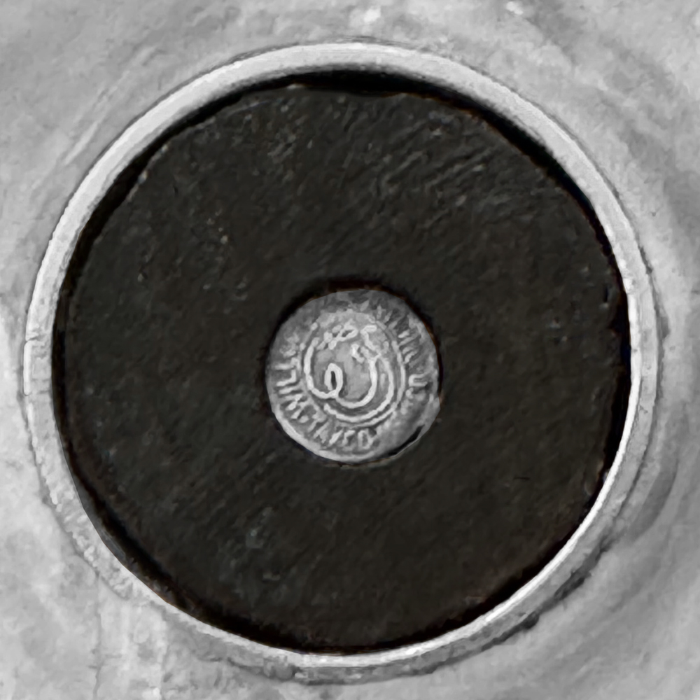 Close-up of a circular metal mark.
